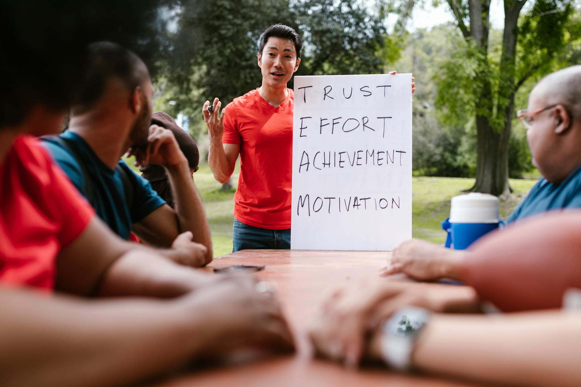 Diverse group engaged in outdoor team building, highlighting trust and effort.